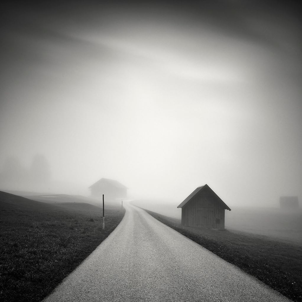 Nevoeiro na estrada, com casas. Mistério.